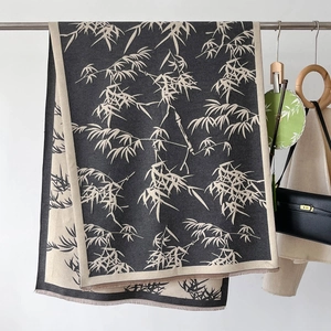 Detailed texture of bamboo leaf print on a long winter shawl with fringe tassels
