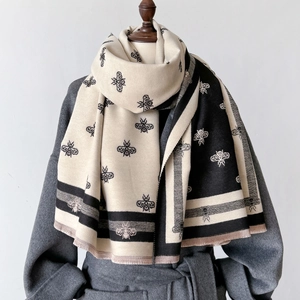 Classic beige and black geometric bee jacquard scarf with thick fringes on a model