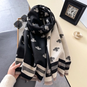 Detailed view of bicolor woven scarf with bee jacquard pattern and soft fringe edges