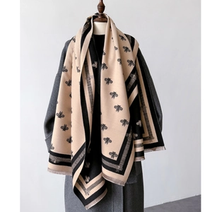 Detail showing bee jacquard pattern and tassel edges on thick reversible cashmere scarf