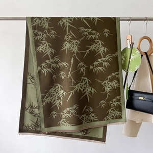 Detail of elegant bamboo leaf print on a dark brown long scarf with fine fringe trim