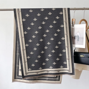 Detail shot of cashmere texture scarf with honeybee pattern and striped edge accents