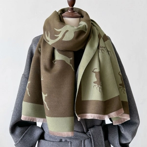 Vue détaillée d'écharpe d'hiver à motif de cerf en laine vert olive et pompons à franges
