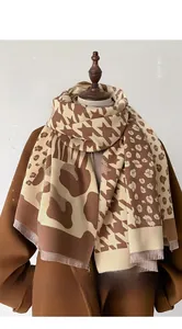 Detail of cashmere-like scarf showing fringe and mixed houndstooth and leopard patterns