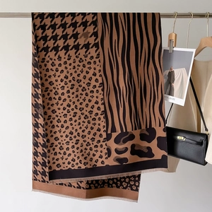Detail of tassel edges and patchwork animal prints on a warm houndstooth winter shawl