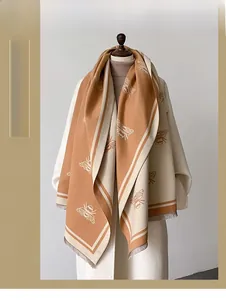 Close-up of winter thick shawl with bee pattern embroidery and soft fringe details