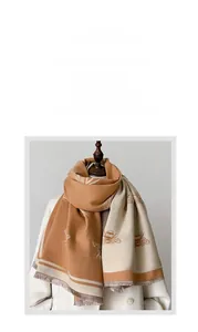 Detail of winter thick scarf with bee pattern, camel patchwork and tassel fringe