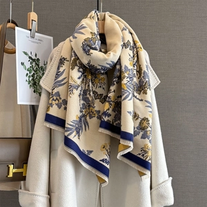 Detail of vintage floral pattern on thick beige cashmere-feel scarf with fringe edges