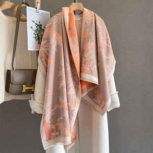 Vintage floral cashmere-feel scarf with tassels draped over a white wool coat