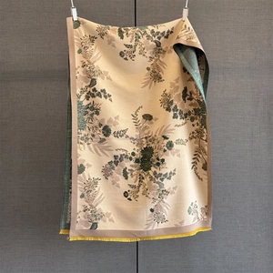 Detail of vintage floral pattern on beige cashmere-like scarf with yellow fringe trim