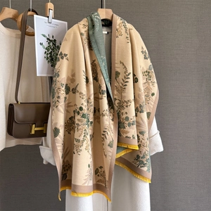 Detail of floral jacquard shawl with yellow tassels on a beige cashmere feel fabric