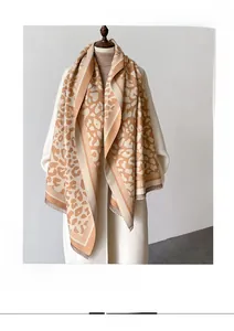 Detailed view of leopard print cashmere feel scarf with soft fringes on white coat