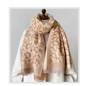 Detail of soft leopard print scarf with tassels shown on a model for a warm thick texture