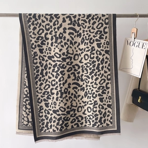 Macro detail of leopard print cashmere scarf showing fringe tassels and side borders