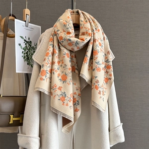 Elegant beige cashmere-like scarf with orange rose prints and fringe on white coat