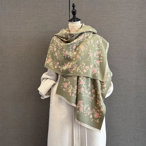 Detailed view of the soft cashmere-feel fabric with pink rose prints and fringe edges