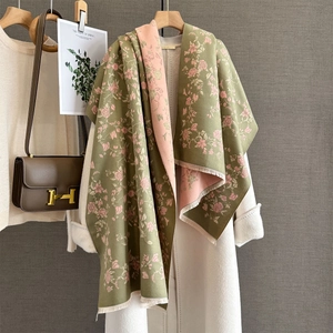 Detail of green and pink rose floral pattern shawl with soft fringe on a winter coat