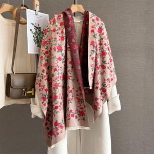 Floral cashmere scarf with red roses on beige, draped over a wool coat for autumn