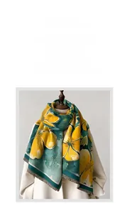 Detail view of ginger yellow floral pattern on dark green cashmere-feel winter shawl