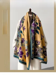 Detail of yellow floral scarf with purple flowers, green piping, and fine tassels