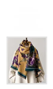 Close-up of yellow winter scarf with purple floral print and dark green fringed edge