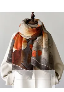 Detail of soft winter scarf featuring orange ginkgo leaves and fine fringed edges