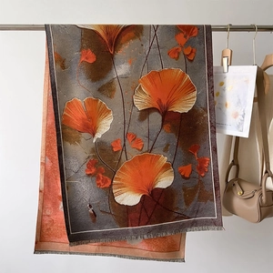 Thick autumn winter scarf featuring orange ginkgo leaf prints and fine fringe details