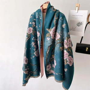 Teal and pink jacquard floral scarf with fringes displayed on a wooden hanger
