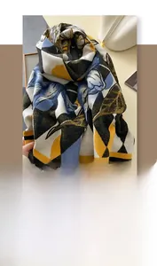 Detail of artistic color block cashmere-like scarf with soft geometric floral patterns