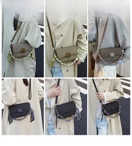 Detail of square crossbody bag with silk scarf wrapped chain and striped texture
