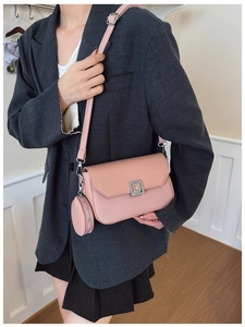 Detail of pink crossbody bag with woven texture, square clasp and matching coin purse