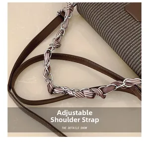 Close-up of the adjustable shoulder strap with silver chain and woven texture details