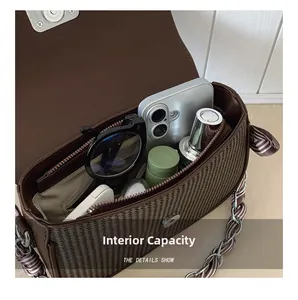 Detail of spacious brown woven handbag interior with phone and sunglasses inside