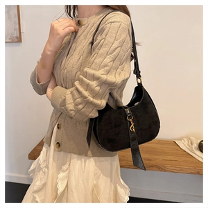 Detail of vintage black crescent bag with matte texture and gold metal buckle closure