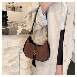 Detail of vintage faux suede crescent bag with dark brown texture and golden clasp