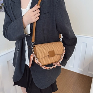 Retro straw weave crossbody bag with leather strap and chain handle worn by a model