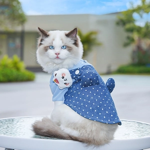Close-up of polka dot denim pet dress with a cute plush bear on blue ragdoll cat