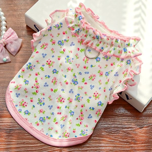 Close-up of floral pet vest with ruffled collar and metal D-ring for leash attachment