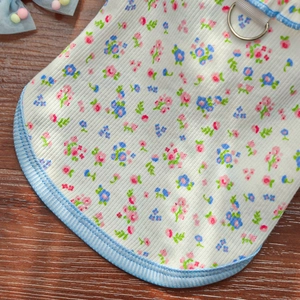 Detail of floral pet dress showing striped fabric texture and silver metal D-ring attachment