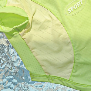Close-up of neon green dog vest with breathable mesh fabric and sport logo detail