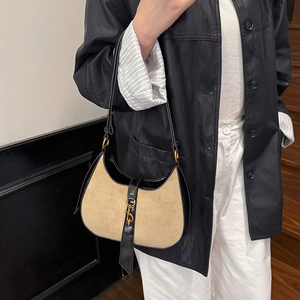 Brown suede crescent hobo bag with black leather trim and metal piston closure