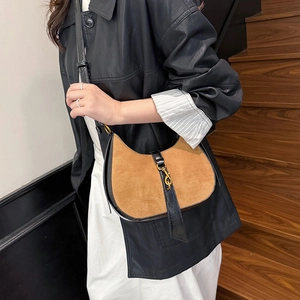 Vintage suede crescent bag in brown and black leather worn on shoulder by model