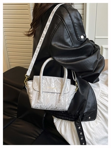 Silver-grey wrinkled texture handbag showing details of gold text and leather strap