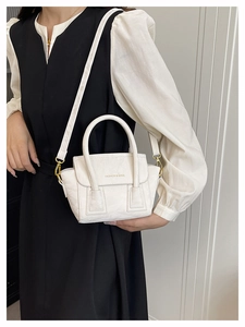 Detail of white pleated texture tote bag with gold logo and detachable shoulder strap
