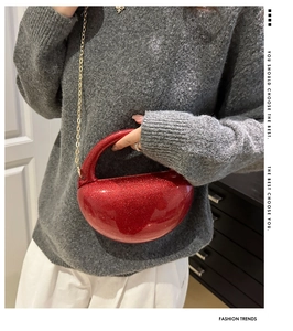 Detail of red sequin bean-shaped clutch bag with gold chain and handle opening
