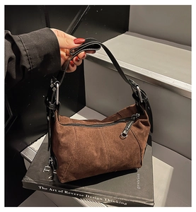 Dettaglio borsa hobo in camoscio marrone con cuciture a contrasto e tracolla nera regolabile