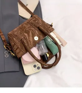 Macro shot showing large storage capacity of a dark brown pleated leather handbag