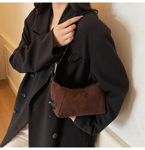 Dettaglio della borsa hobo in pelle scamosciata marrone con zip in metallo