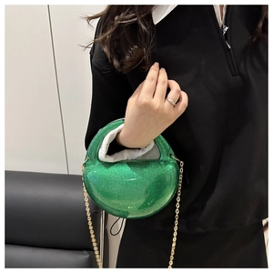 Detail of green glitter sphere evening clutch bag with gold chain and semi-circular handle
