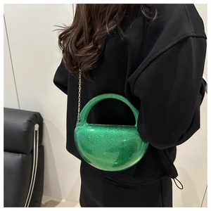 Detail of green glitter acrylic half-moon bag with golden chain and sparkle texture